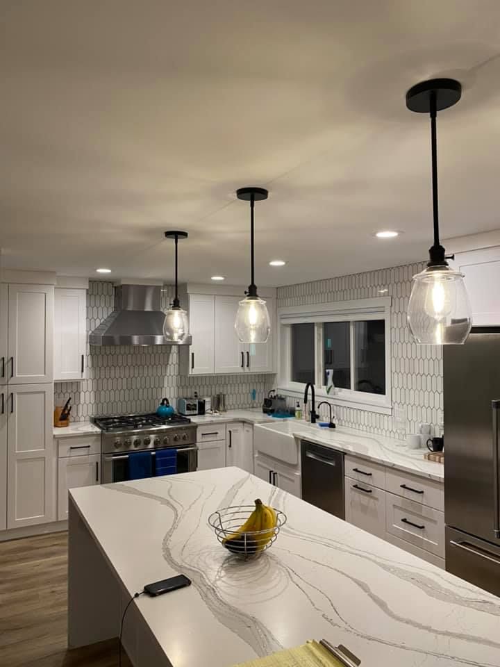 Kitchen with quartz waterfall island, pendant lights and tile backsplash